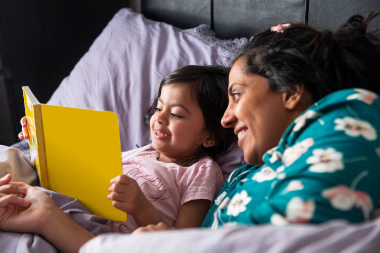 Mother and daughter share a bedtime story as part of a daily reading routine.